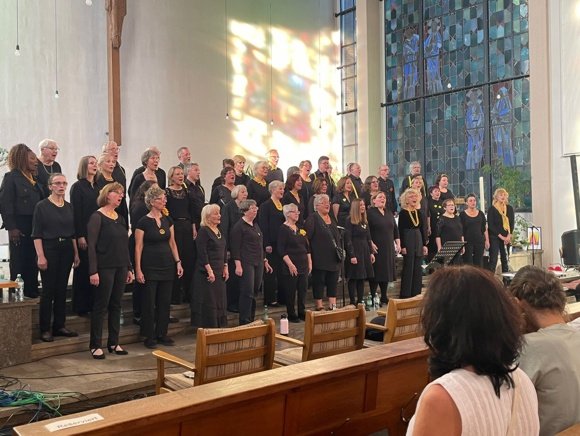 Bild: Chor seitlich fotografiert, emotional singend.