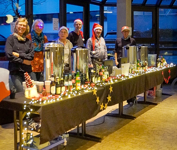 Bild: Das Team vom Afterglow, weihnachtlich angezogen mit M�tze und Glimmer, vor der Auslage von Getr�nken und Knabberreien.